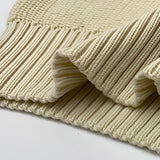 
A women's oversized red stripe off-shoulder sweater laid on a wooden surface, showcasing its long sleeves and cozy wool texture, ideal for autumn fashion.