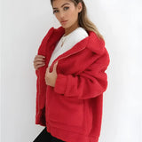 
A woman wearing an oversized red teddy coat with long sleeves and a plush texture, suitable for winter. The coat is designed with a wide collar and falls to the waist, creating a stylish and cozy look. The model showcases the coat in a fashion setting.