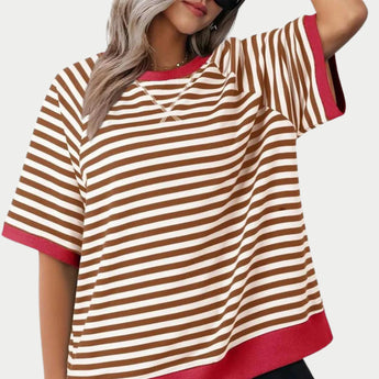 
A woman wearing an oversized red and pink striped tee with a loose fit, featuring long sleeves and a round neckline.