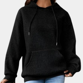 Women's oversized textured black hoodie with a casual loose fit, featuring long sleeves and a relaxed neckline.