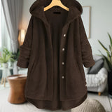 Women's oversized wool hooded sweater coat in brown, size 5XL, displayed on a mannequin with a grey background. The coat features long sleeves, a cozy hood, and is styled with a collar. A houseplant in a flowerpot is also present nearby.