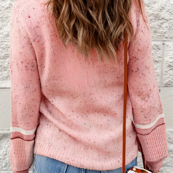 Alt text: A women's pastel pink knit sweater featuring a cozy and lightweight design, with a round neckline and long sleeves. The sweater is casually styled and worn over a pair of grey jeans.