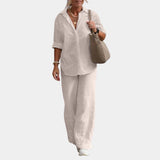 Women's pink linen suit in apricot color, featuring a casual summer set with a button-down shirt, shown in XL size. The image highlights the suit's tailored blazer with a collar, buttoned sleeves, and waist detailing, as well as the overall fit on a model, showcasing the shoulder, arm, and hand positioning.