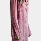 A woman wearing a pink oversized long sleeve linen shirt, styled casually with jeans. The shirt features a breathable fabric with a collar and button-down design, offering a comfortable and relaxed look.