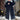
Image of a woman standing in the snow, wearing an oversized plush black teddy coat with a collar and long sleeves, suitable for winter fashion.