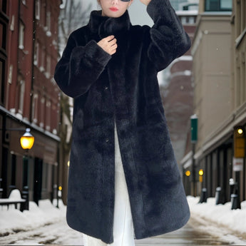 
Image of a woman standing in the snow, wearing an oversized plush black teddy coat with a collar and long sleeves, suitable for winter fashion.