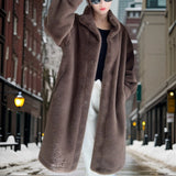 Women's brown oversized teddy coat in plush fabric, featuring a cozy design suitable for winter fashion. The coat has long sleeves, a wide collar, and a soft fur-like texture, shown in an XL size.