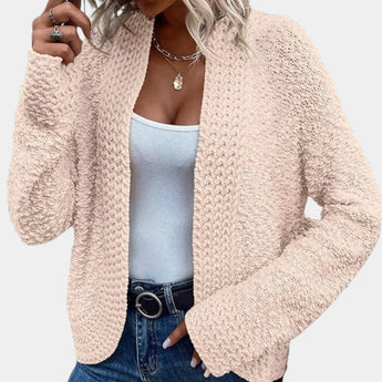 
A women's fluffy pink teddy coat designed for cozy winter wear, shown in an apricot color and extra-large size. The image highlights the soft plush texture of the outerwear, with attention to the collar and shoulder area, emphasizing its fashionable and comfortable design. A woman's hand is partially visible, showcasing the fit of the coat around the arm and neck.