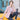 Women's light tan plaid blazer with pink accents, styled casually for office or street wear, paired with jeans and a dress shirt, photographed in an outdoor setting.