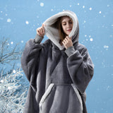 
A woman wearing a plush oversized fleece hooded winter robe, smiling outdoors in a snowy environment.