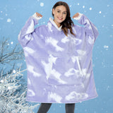 
A woman smiling and wearing a plush oversized fleece hooded winter robe in purple velvet, showcasing its long sleeves and cozy design.