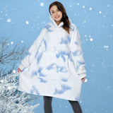 Woman wearing a blue plush oversized fleece hooded robe standing in a snowy outdoor setting with trees in the background.