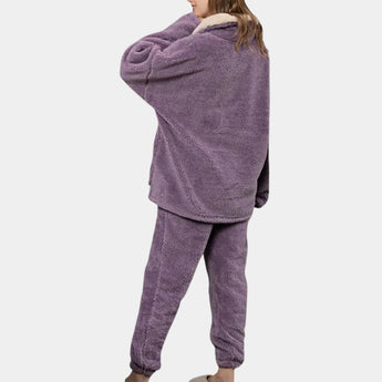 Women's purple fleece pajama set featuring a plush hoodie with long sleeves and matching relaxed fit pants.