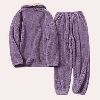 Women's purple fleece pajama set featuring a plush hoodie, with long sleeves and a cozy, woolen texture. The loungewear is primarily in shades of purple and violet, offering a soft and comfortable fit for relaxation.