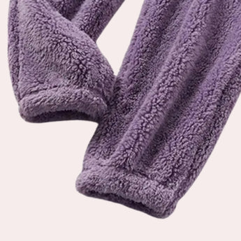 Women's purple fleece pajama set featuring a plush hoodie with creative arts-inspired patterns in shades of purple and magenta, made of soft woven woolen fabric.
