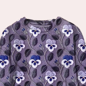 Purple crewneck sweater for women featuring floral embroidery with vibrant violet, magenta, and electric blue flower patterns on the sleeves and body.