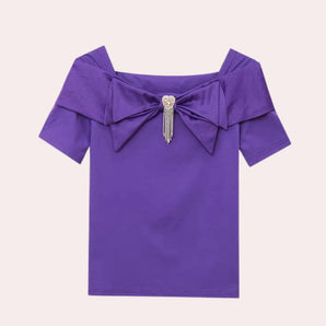 Women's purple off-shoulder blouse with a bow and rhinestone detailing, featuring a stylish sleeve design.