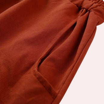 A pair of women's red bohemian harem pants featuring an elastic ankle and a drawstring waist, displayed in a relaxed style.