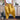 A pair of women's red bohemian harem pants, featuring an elastic ankle and drawstring waist, laid on a wooden floor with a yellow decorative element nearby.