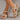 Women's beige leather buckle sandals on a human foot, showcasing stylish and comfortable summer footwear design.