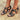Women's red leather chunky heel strappy sandals featuring gold buckles, shown worn on a foot with visible toes.