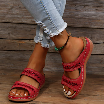 Red leather platform sandals for women, featuring a stylish design suitable for summer. The sandals have a comfortable platform sole, and they are displayed on a human foot to highlight their aesthetic and fit.