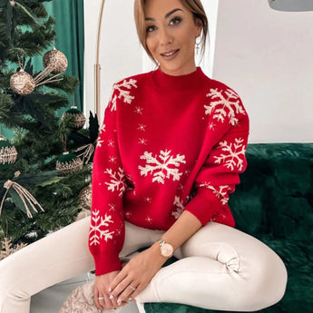 
A woman wearing a red snowflake Christmas sweater, showcasing festive holiday knitwear. The sweater has long sleeves and is styled in a way that highlights fashion elements. She is smiling, and the sweater fits at the waist, extending to the thighs. The Christmas ornament design adds to the holiday theme.