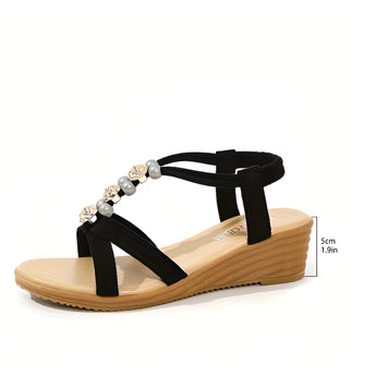 Women's chic black rhinestone wedge sandals on a beige wood surface showcasing summer fashion and comfort.