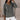 A plus-size gray cable knit chunky sweater featuring a V-neckline, long sleeves, and a relaxed fit, designed for women's comfort and style.