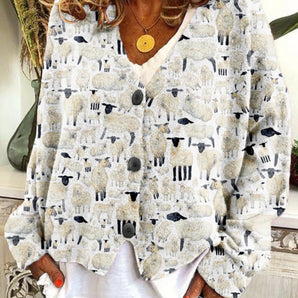 White women's blouse with a sheep print design, featuring a collar and long sleeves, made from lightweight textile material.