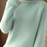 A close-up image of a women's green slim fit turtleneck sweater featuring ribbed cuffs, suitable for winter fashion.