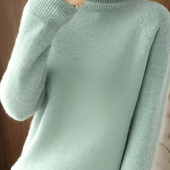 A close-up image of a women's green slim fit turtleneck sweater featuring ribbed cuffs, suitable for winter fashion.