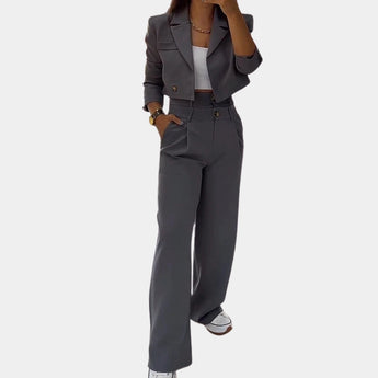 Women's slim fit gray business suit featuring a high-waisted design; includes a tailored blazer and matching pants, suitable for a modern office setting. The suit in size 2XL showcases a sleek and professional look with a structured collar and defined waistline.