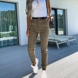 
A pair of women's slim fit olive green chinos with a high waist and tapered leg design, modeled by a person standing.