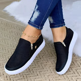 Women's slip-on sneakers in Nero color, size 43, featuring a breathable mesh material and lightweight design with a convenient zipper closure, styled with denim jeans.