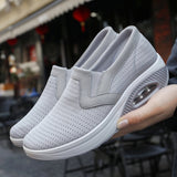 Gray women's slip-on walking sneakers featuring a lightweight and breathable design with arch support, suitable for outdoor activities and athletic wear.