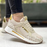 Women's grey sneakers with gold accents, shown in a casual chic style. The sneakers are designed for walking and outdoor activities, featuring a trendy and sporty look. The image conveys a sense of movement and athleticism.