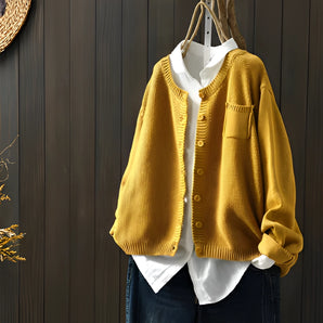 Women's soft knit cardigan sweater in yellow displayed on a clothes hanger, showcasing its long sleeves, collar, and casual yet elegant design. The cardigan is in size 3XL.