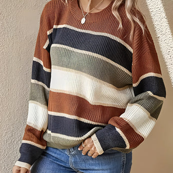 A woman wearing a multicolor striped crew neck sweater paired with jeans. The sweater features a mix of vibrant fall colors with a knit texture, showcasing a casual yet stylish look.