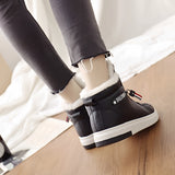 A pair of women's stylish high-top sneakers in pink, showcasing a trendy design with a comfortable fit. The sneakers are paired with a casual outfit, highlighting their versatility and modern appeal.