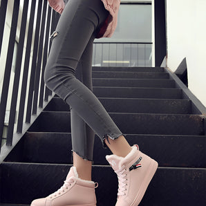 Women's stylish pink high-top sneakers worn by a person, showcasing their trendy design and comfortable fit against a minimal white background.