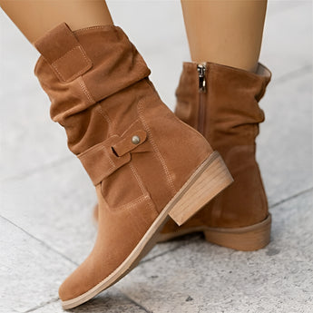 Brown women's suede ankle boots with buckle strap and zipper, featuring a low heel.