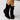 Black women's suede ankle boots featuring a buckle strap and side zipper, designed with a low heel and stylish fashion elements.