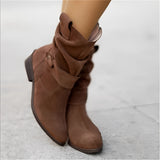 Women's dark brown suede ankle boots with a buckle strap and zipper, featuring a low heel.