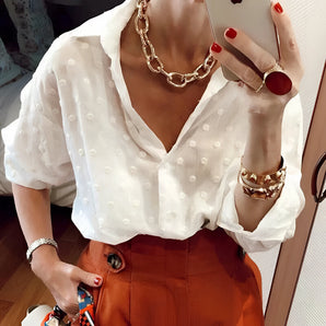 White swiss dot V-neck blouse with puff sleeves for women, featuring a fashion-forward design suitable for various occasions.
