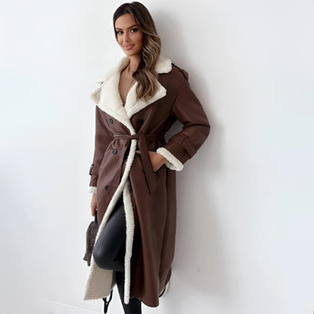 Women's tan double-breasted shearling trench coat in size XL, featuring a classic overcoat design with a notched collar, long sleeves, and a fitted waist. The coat falls to knee length, showcasing a stylish and fashionable design suitable for colder weather.