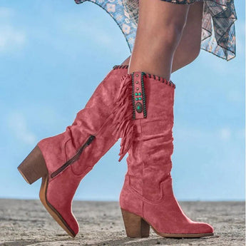 Women's mid-calf tan suede fringe boots with a Western Boho style, featuring a slight heel, worn by a person outdoors.