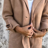 Elegant women's tan wool coat in a camel color, featuring a notch collar, long sleeves, and a tailored fit. The coat is styled over a dress shirt, accentuating the neck and waist areas. Available in Cachi color and 5XL size.