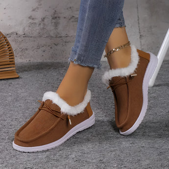 Women's turquoise slip-on shoes with fur lining, designed for stylish winter wear, shown in an indoor setting.