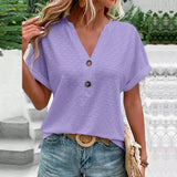 Women's short sleeve V-neck textured blouse with geometric patterns in purple.